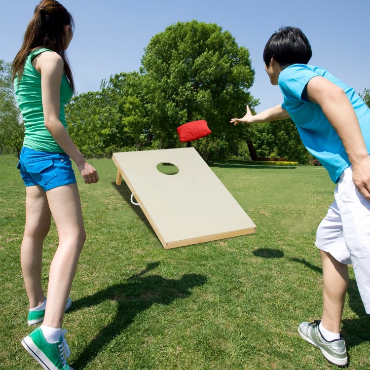 Solid wood cornhole board set with a player tossing a bean bag, includes 8 bags for outdoor fun and easy storage.