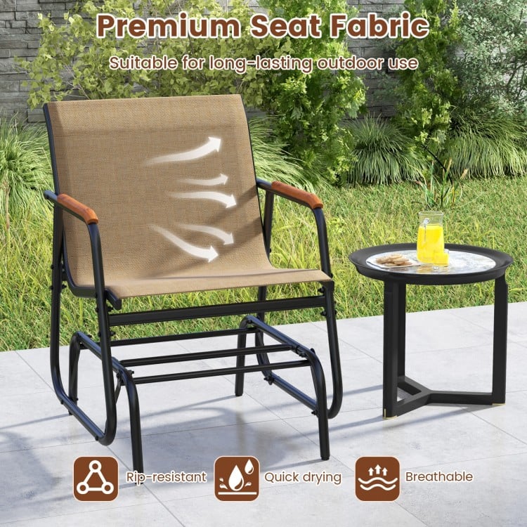 Patio glider chair with curved teak armrests and breathable fabric, ideal for backyard or poolside relaxation.