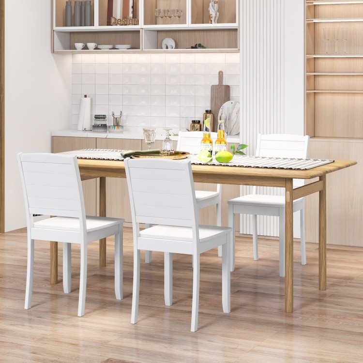 White armless dining chairs with rubber wood legs, featuring a curved backrest for comfort and a rustic farmhouse style.