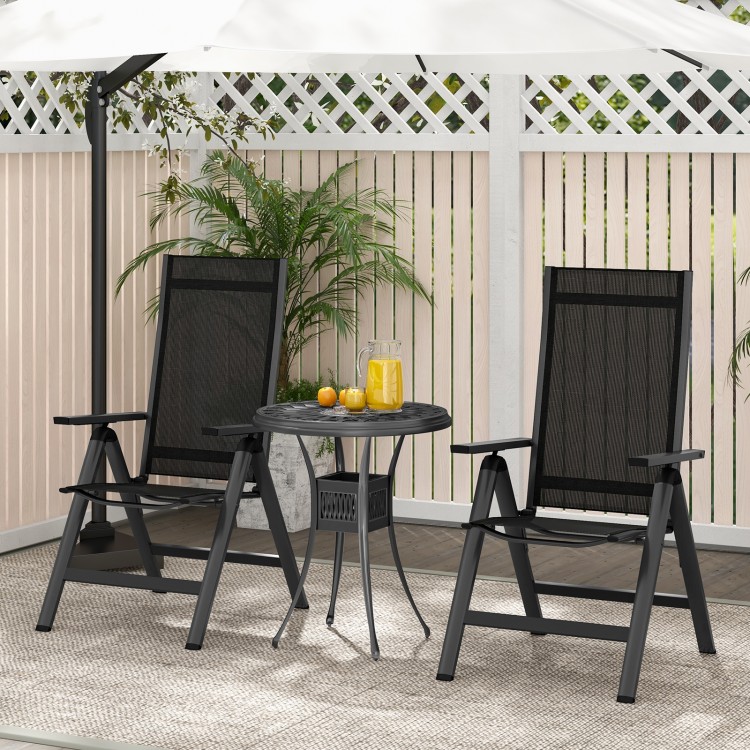 Two black outdoor dining chairs with padded seats and adjustable backrests, set on a patio with a small table.
