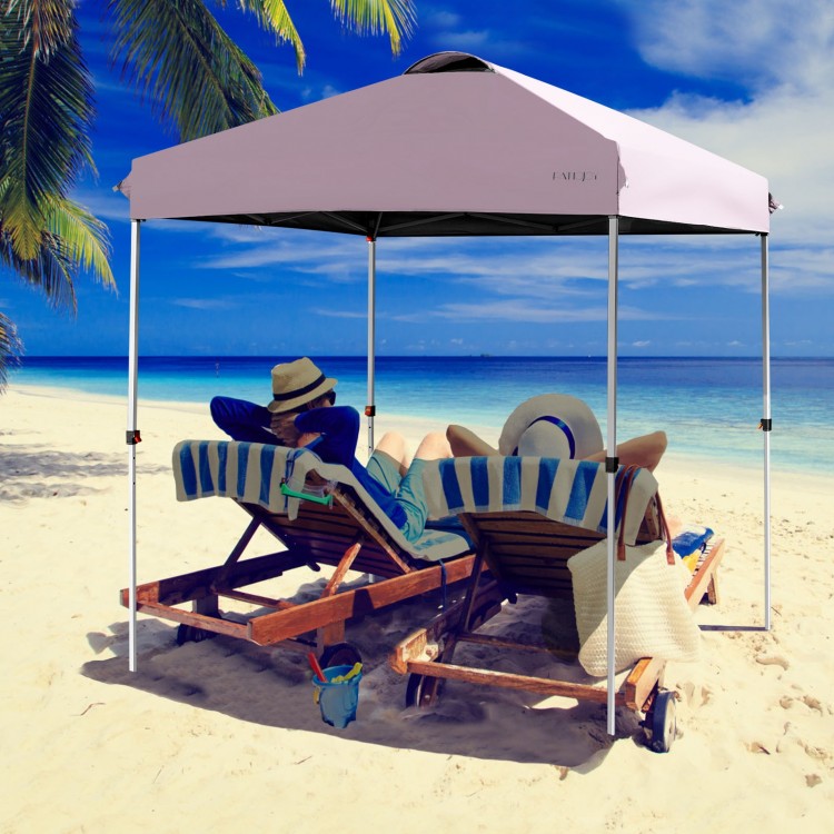 Outdoor pop-up canopy tent in pink, 6.6' x 6.6', providing shade for beach relaxation with adjustable height options.
