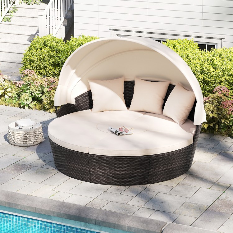 Round patio daybed with retractable canopy, PE rattan, and plush cushions, ideal for poolside relaxation.