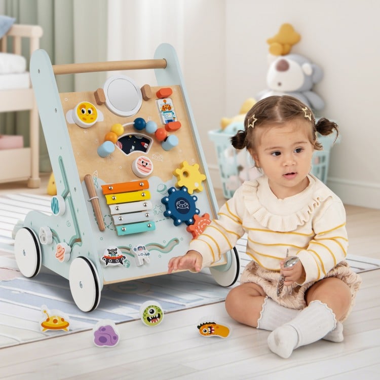 Wooden baby walker activity center in green with wheels, featuring a xylophone, mirror, and shape sorters for toddlers.