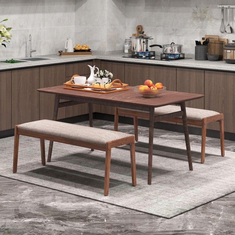 Backless bench with rubber wood legs and beige fabric padded seat, perfect for farmhouse-style dining rooms.