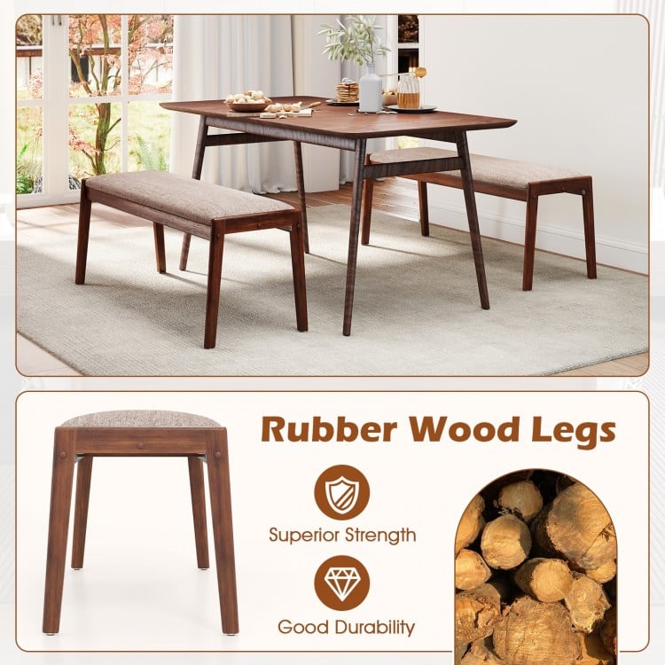 Backless bench with rubber wood legs and beige fabric padded seat, ideal for dining rooms or entryways.