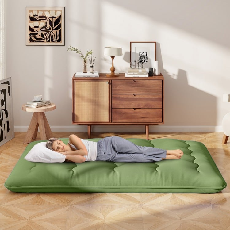 Full-size floor mattress in green with a washable cover, shown in a cozy living space, ideal for sleeping or yoga.