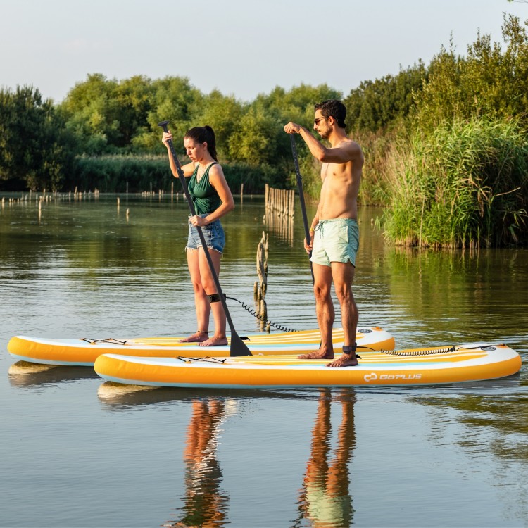 Two people paddle on inflatable stand-up paddle boards in a serene water setting, showcasing stability and versatility.