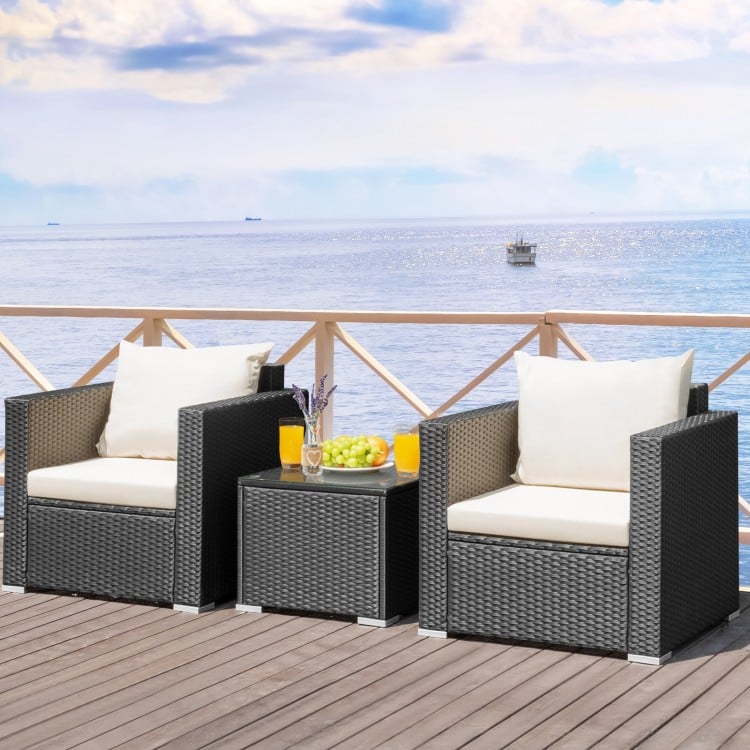 Two-piece patio wicker furniture set with white cushions and a glass-top table, perfect for outdoor relaxation.