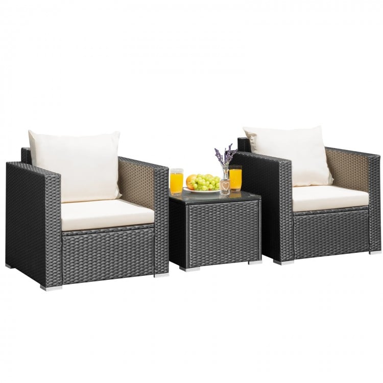 Two cushioned patio chairs and a glass-top table in a wicker furniture set, perfect for outdoor relaxation.