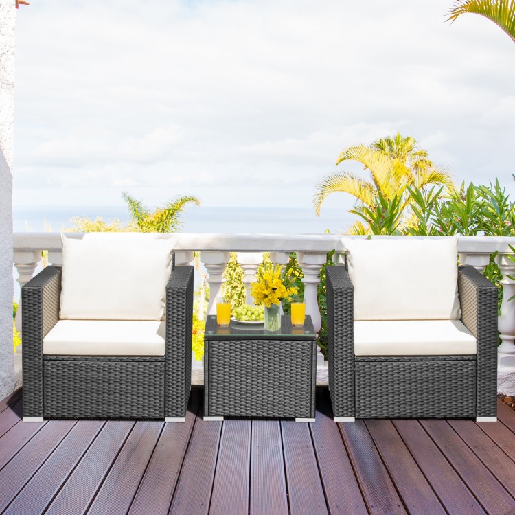 Two cushioned patio chairs and a glass-top table in a garden setting, perfect for outdoor relaxation.