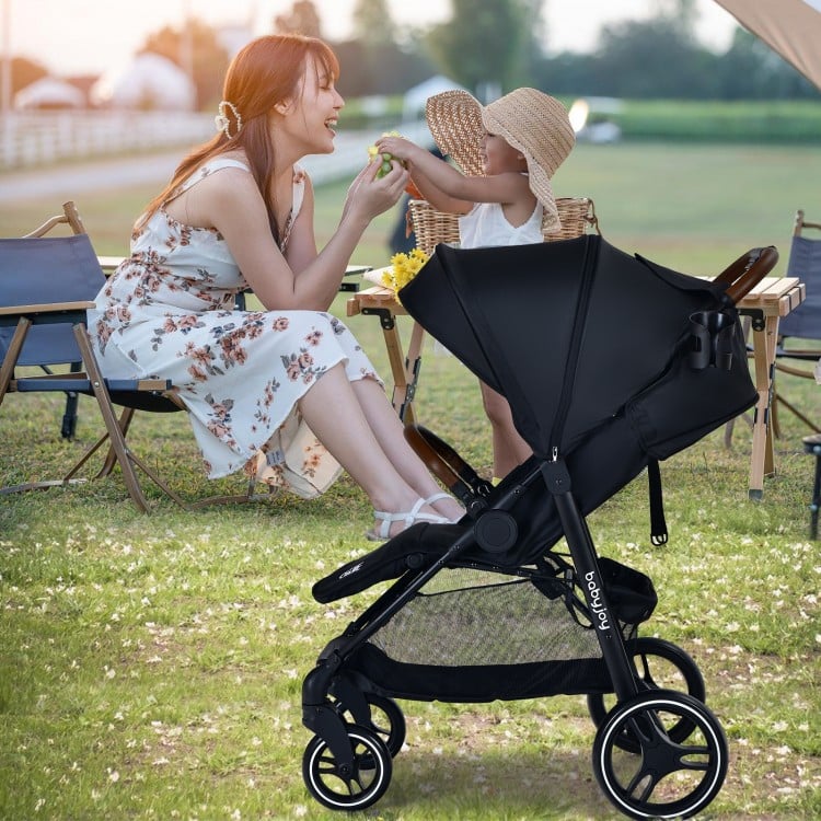Lightweight black infant stroller with adjustable backrest, 5-point harness, and detachable foot cover for safety and.
