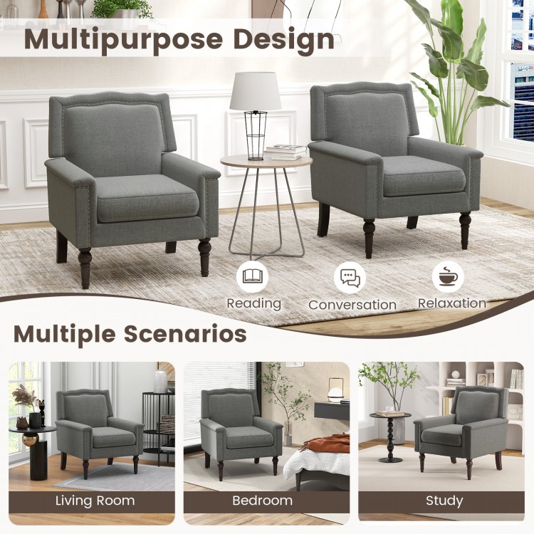 Gray mid-century modern armchair with thick cushion and nailhead trim, ideal for reading and relaxation in any room.