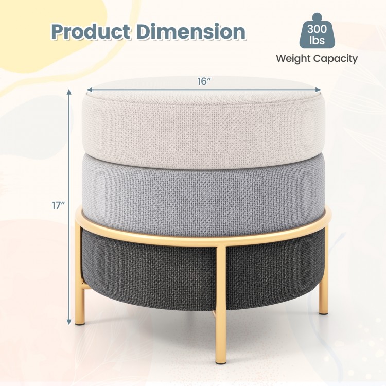 Round upholstered ottoman in gray with gold metal legs, 300 lbs capacity, ideal for living room or bedroom use.