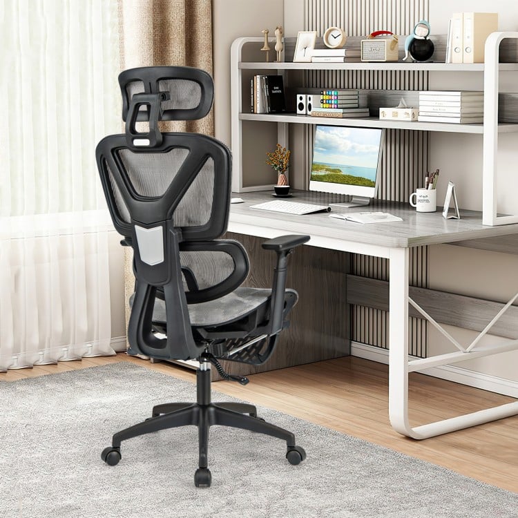 Gray mesh office chair with tilting backrest and retractable footrest, designed for comfort and stability in a.
