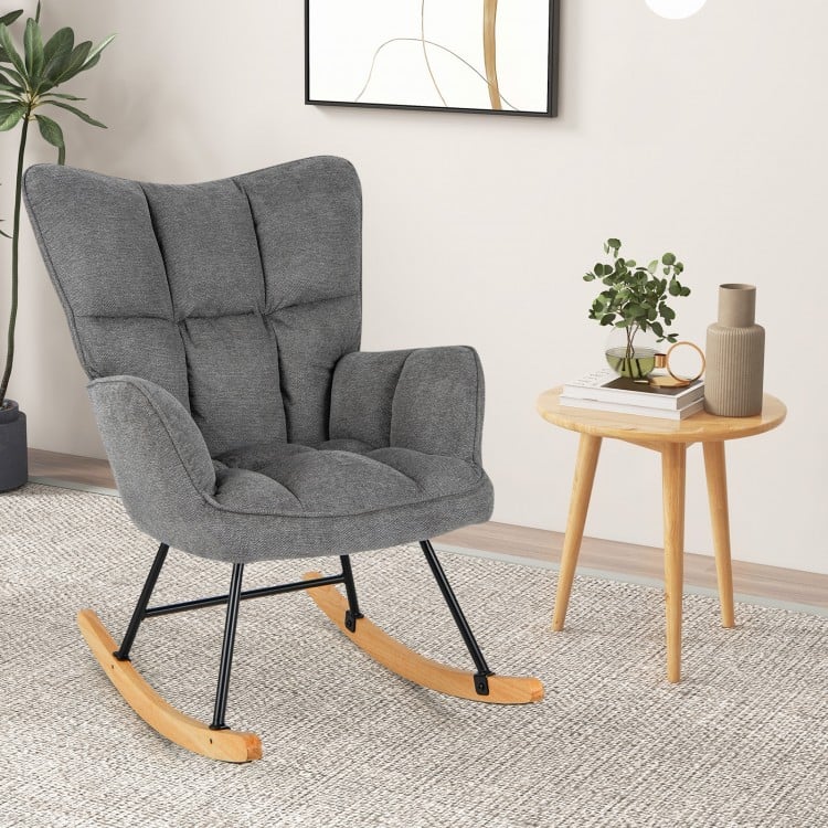 Gray linen nursery rocking chair with high backrest and padded armrests, perfect for relaxing in living rooms or.