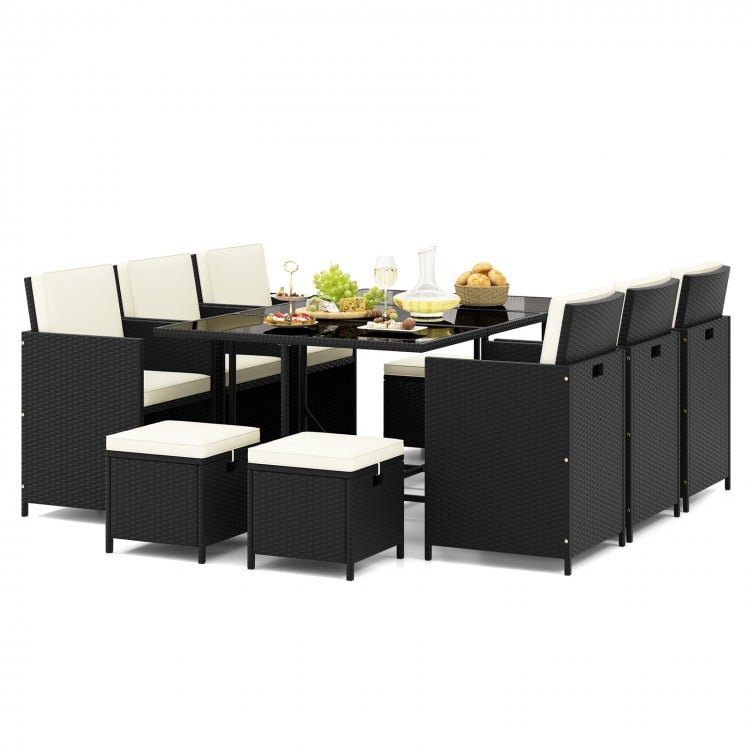 11-piece patio dining set with black wicker chairs, white cushions, and tempered glass table for outdoor dining.