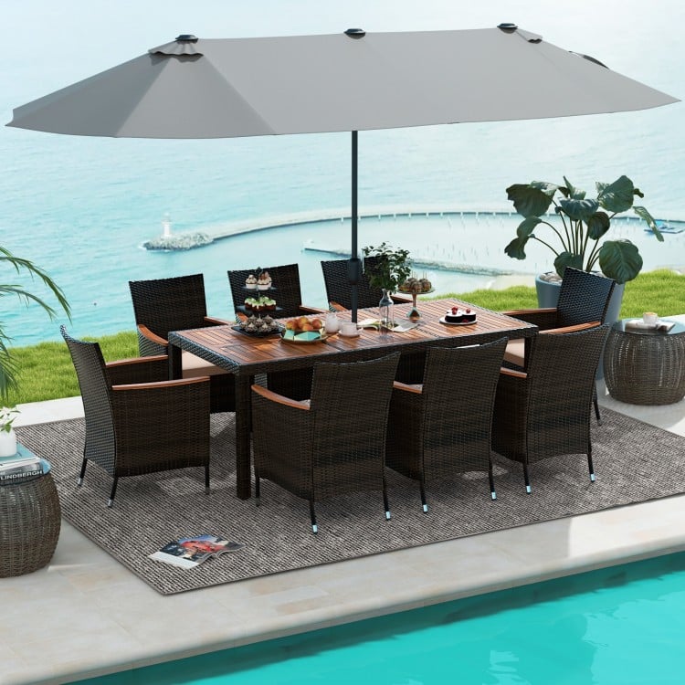 10-piece outdoor dining set featuring a gray double-sided umbrella, rattan chairs, and an acacia wood tabletop for.