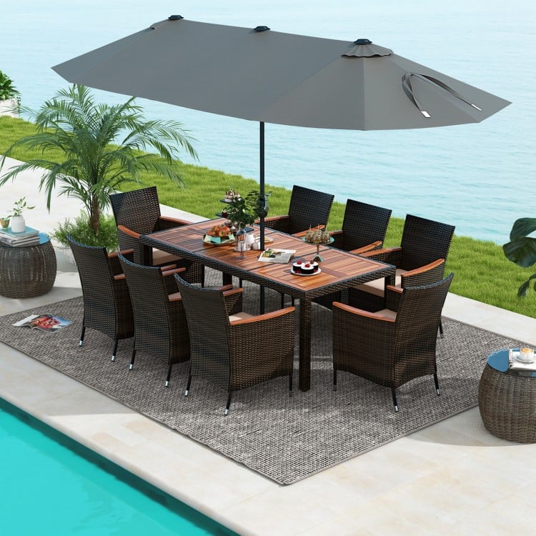 10-piece outdoor dining set featuring a gray double-sided patio umbrella, rattan chairs, and acacia wood tabletop by.