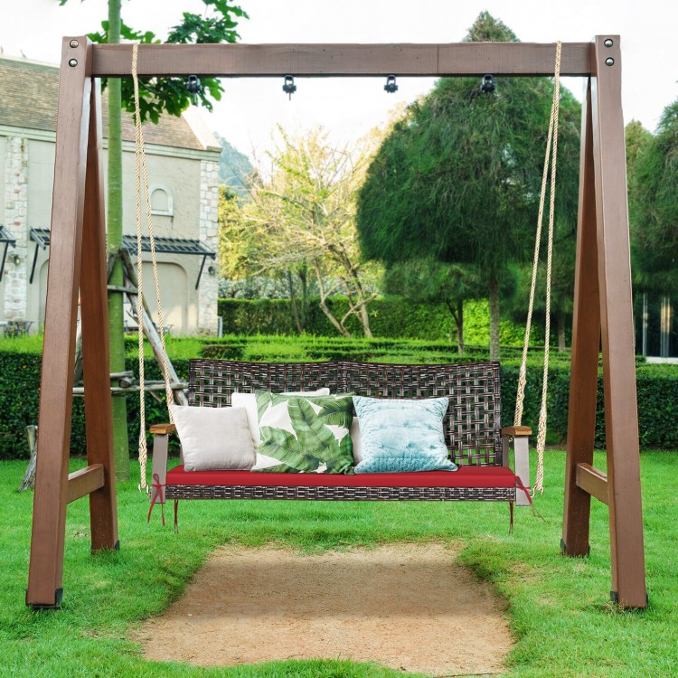 2-person rattan hanging porch swing chair with red cushion, sturdy steel frame, ideal for outdoor relaxation.
