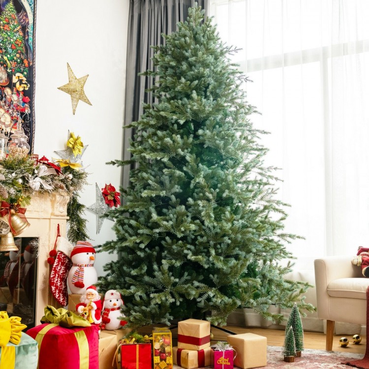 8 feet hinged artificial Christmas spruce tree with mixed PE and PVC tips, set up in a cozy living room for holiday.