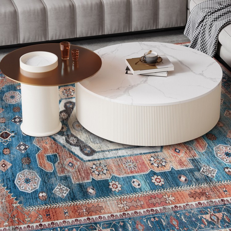 Round coffee table with a marble top beside a vintage area rug, perfect for living room or bedroom decor.