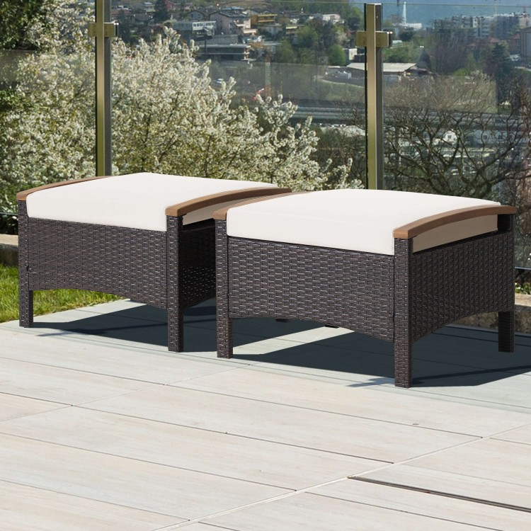 Set of 2 fade-resistant wicker patio ottomans with soft white cushions and acacia wood handles for outdoor use.