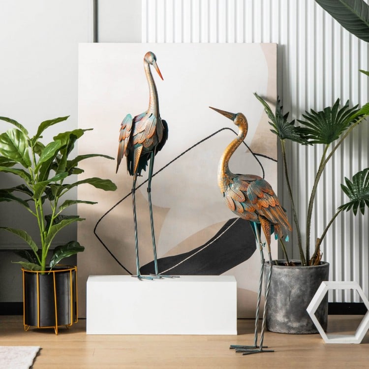 Set of 2 standing metal crane garden statues with detailed feathers, ideal for backyard or lakeside decoration.