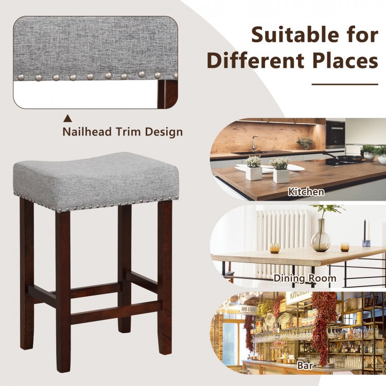 Gray bar stool with cushioned seat and nailhead trim, ideal for kitchen, dining room, or bar use.