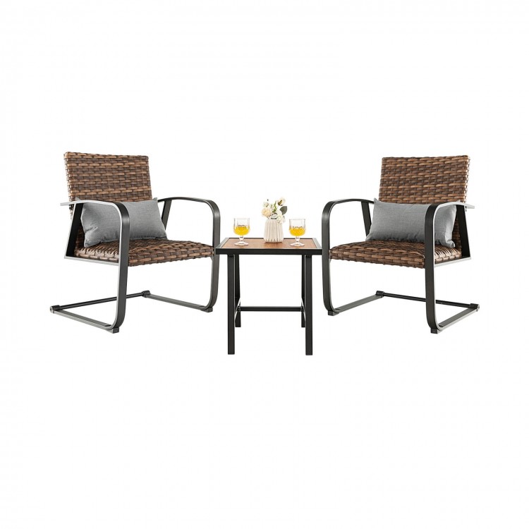 Two rocking chairs with lumbar pillows and a DPC tabletop, made of brown PE rattan, perfect for outdoor relaxation.