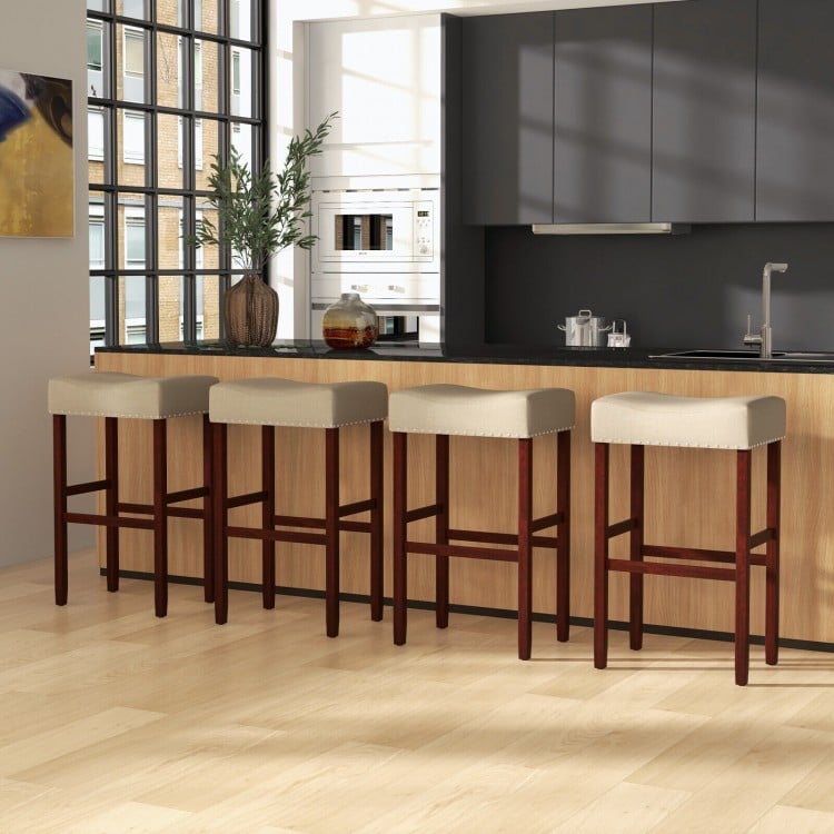 Backless beige upholstered bar stools with solid rubber wood legs, ideal for dining or kitchen use, featuring a.