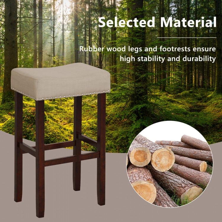 Backless upholstered bar stool with solid rubber wood legs, beige linen fabric, ideal for dining or kitchen use.