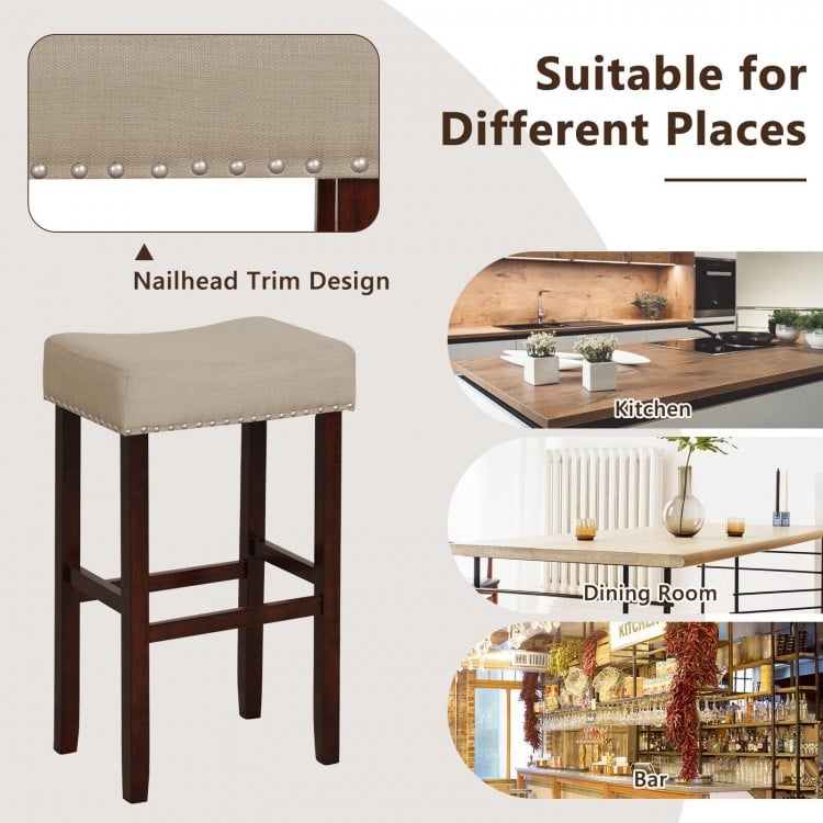 Backless beige bar stool with solid rubber wood legs and nailhead trim, perfect for kitchen, dining, or bar use.