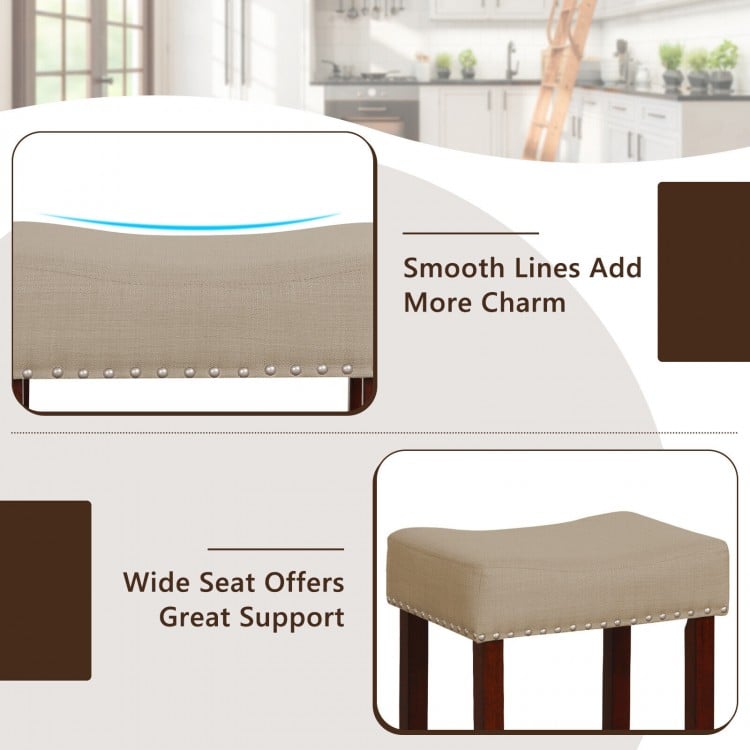 Beige upholstered bar stool with solid rubber wood legs, featuring a wide seat and nailhead trim for stylish support.
