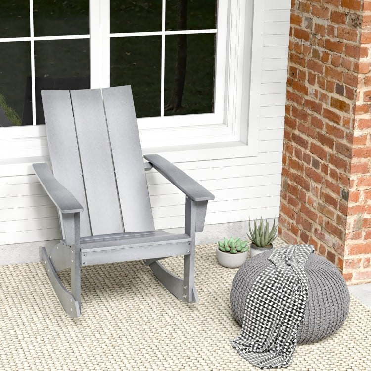 Gray Adirondack rocking chair with curved back and rounded armrests, perfect for balcony relaxation.