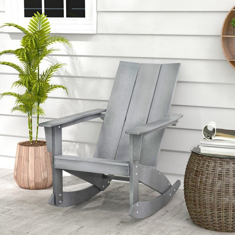 Gray Adirondack rocking chair with curved backrest and rounded armrests, perfect for outdoor balcony relaxation.