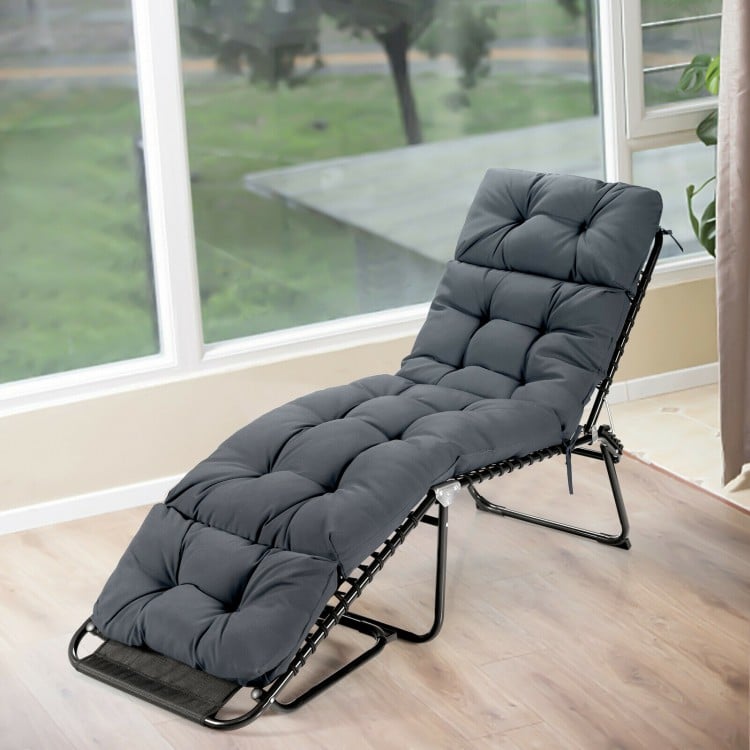 Thick gray outdoor lounge chaise cushion with string ties, made from waterproof polyester for garden or poolside use.