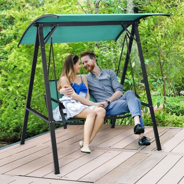 Two-person patio swing with adjustable green canopy, sturdy steel frame, perfect for garden or deck relaxation.