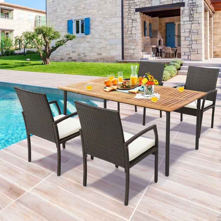 Acacia wood dining table with metal legs, featuring an umbrella hole, set for outdoor dining by the pool.