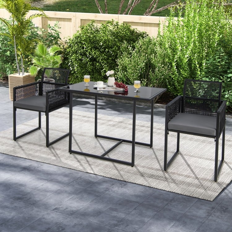 Outdoor dining set featuring a tempered glass table and gray cushioned chairs, perfect for backyard or poolside use.