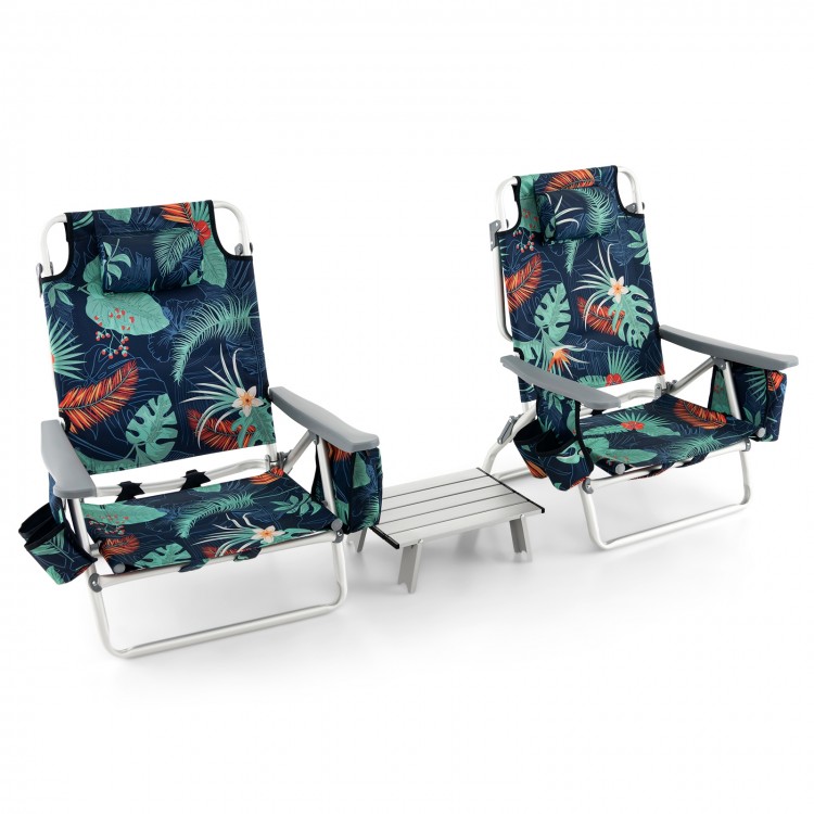Two green tropical-patterned reclining beach chairs with a folding side table, perfect for outdoor relaxation.