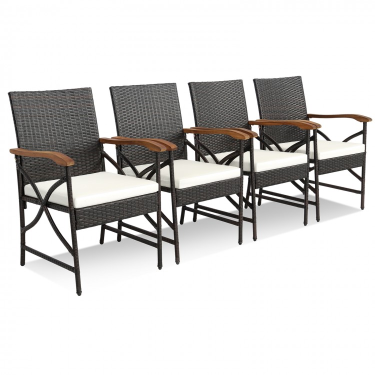 Four outdoor dining chairs made of hand-woven PE rattan with soft cushions and acacia wood accents for stylish comfort.