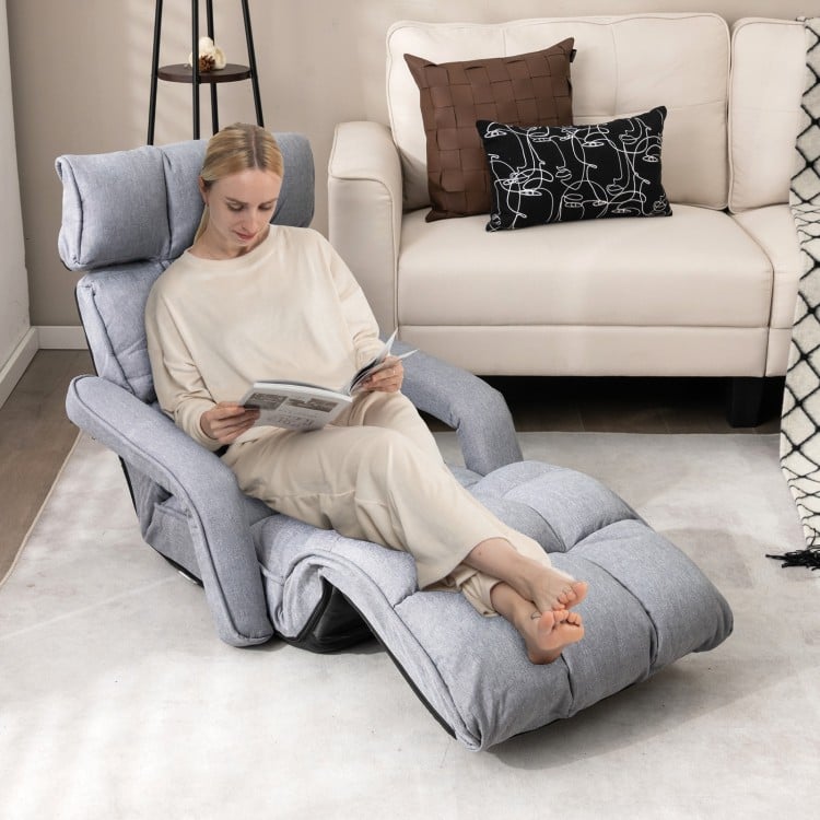 Adjustable gray floor chair with armrests and footrest, perfect for relaxation in living rooms or bedrooms.