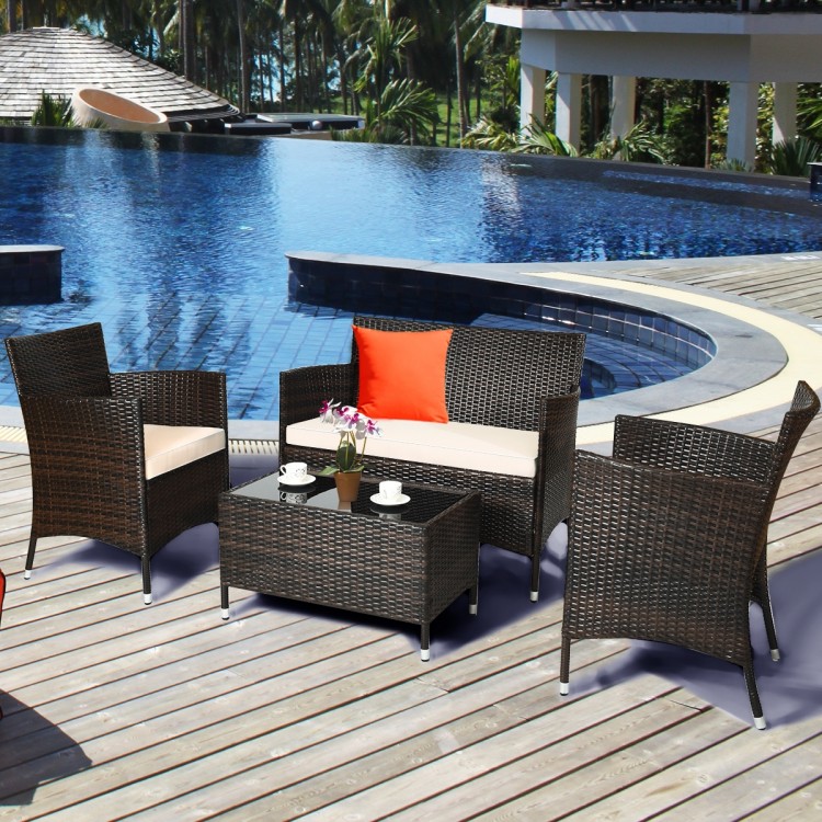 4-piece outdoor rattan sofa set with beige cushions and glass coffee table, perfect for patio or poolside relaxation.