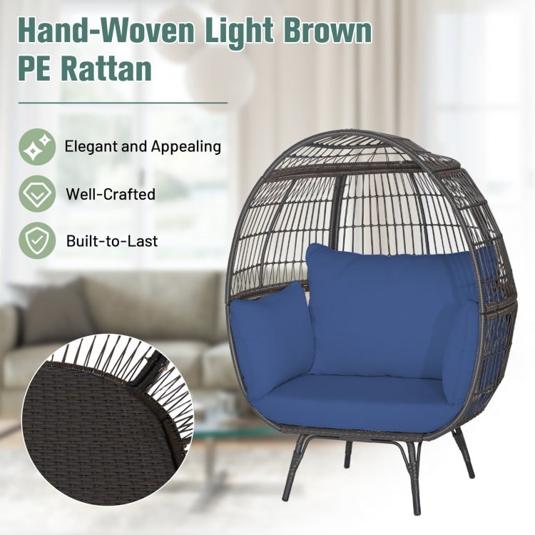 Oversized light brown PE rattan egg lounge chair with navy cushions, perfect for cozy indoor or outdoor relaxation.