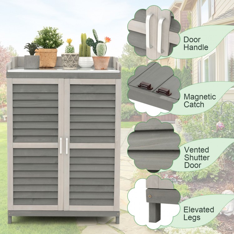 Garden potting bench table in gray with vented shutter doors, elevated legs, and two storage shelves for versatile use.