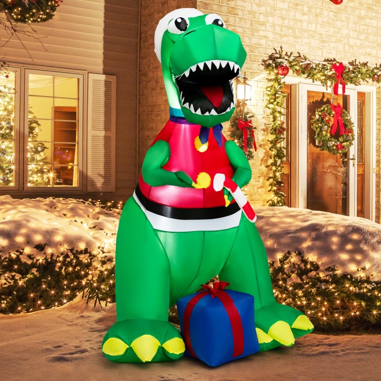 6FT inflatable dinosaur Christmas decoration with LED lights, wearing a hat and holding a gift box for festive outdoor.