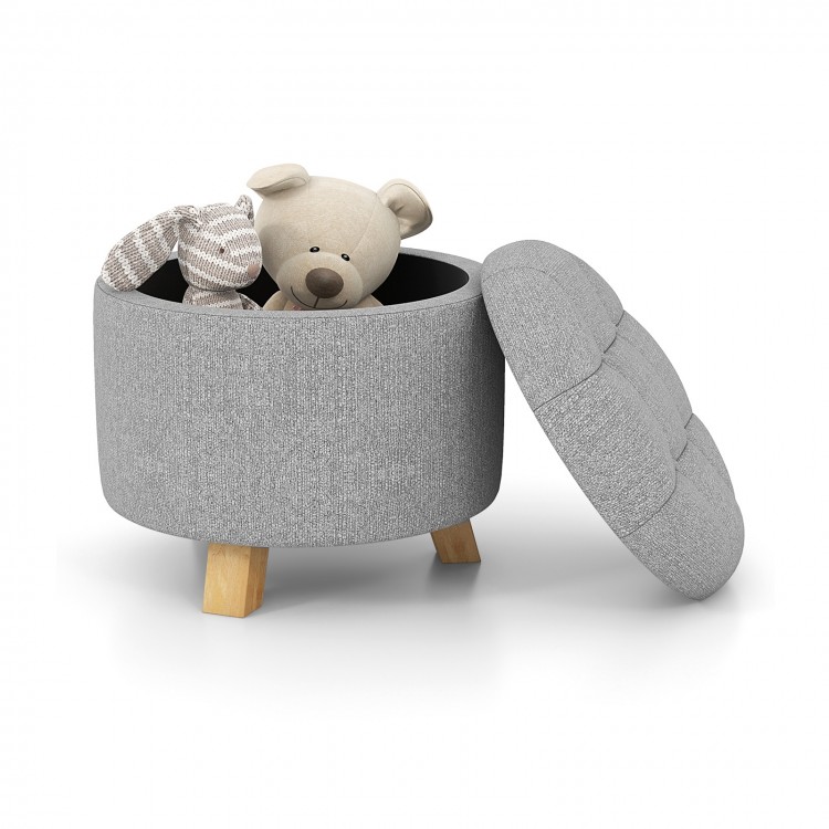 Round gray upholstered ottoman with solid rubber feet, featuring a cushioned seat and ample storage for toys.
