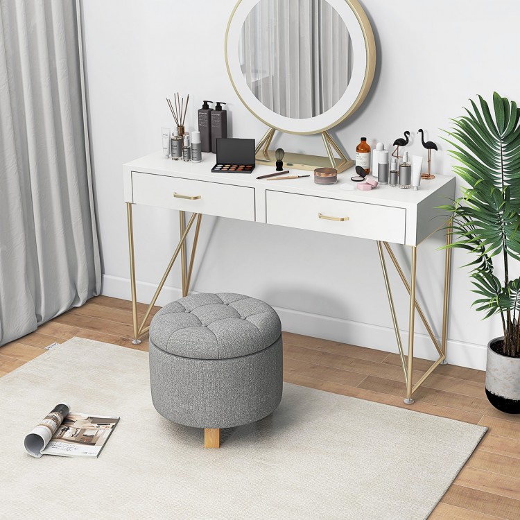 Gray upholstered round ottoman with solid rubber feet, offering storage and comfort for versatile use in any space.