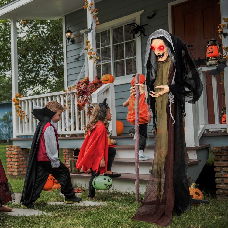 Life-size animatronic witch with red eyes and posable arms, perfect for Halloween parties and outdoor decorations.