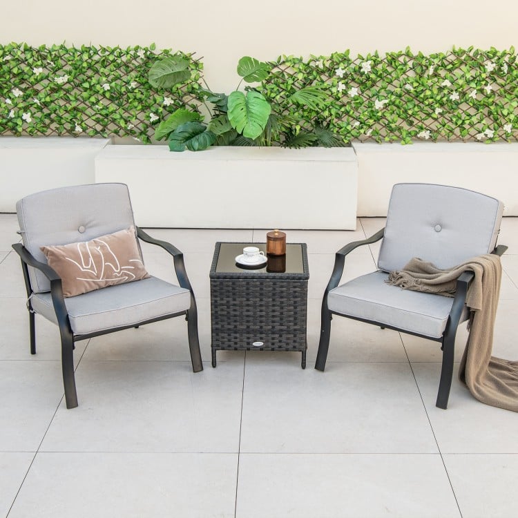 Two ergonomic patio metal chairs with soft cushions and a small side table, perfect for backyard relaxation.